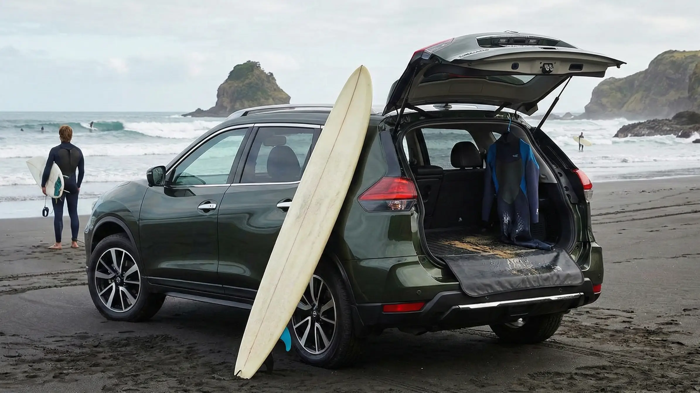 Nissan X-Trail SUV at Raglan beach with surfboard and washable boot showing perfect surf vehicle